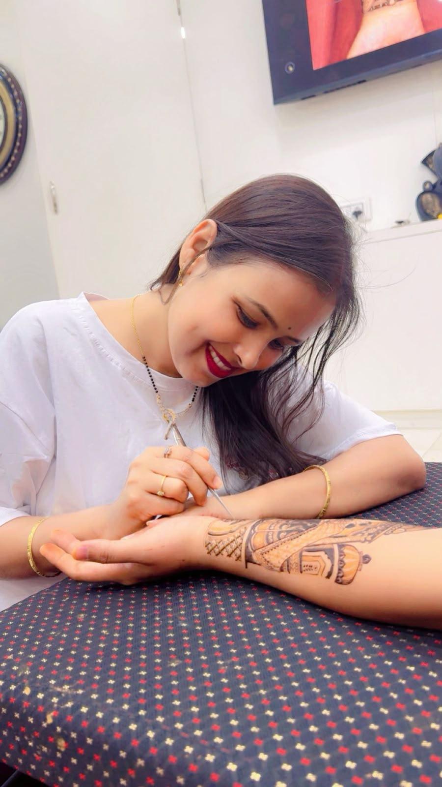 Shweta Gupta smiling while applying an arm design