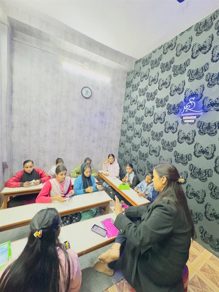 Shweta teaching in the studio with neon butterfly wall